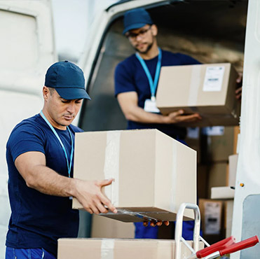 Two delivery workers unloading bulk boxes from a van for Amazon wholesale supplier shipping and logistics services